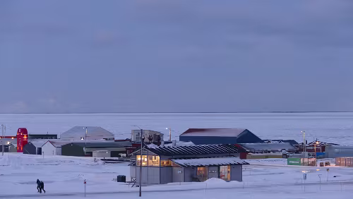Longyearbyen Im Vordergrund wieder ein Feuerhaus und hinten dran Teile des Industriegebietes. Der Adventfjorden ist im Sichtbereich zugefroren