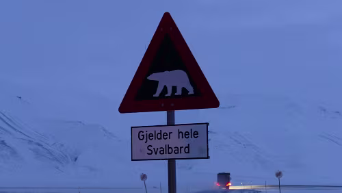 „Longyearbyen in a nutshell“ Tour „Gjelder hele Svalbard“ - „Gilt auf ganz Spitzbergen“. Das Schild steht am Straßenrand der Straße/Piste die von Longyearbyen in Richtung Osten führt, zur Gruve...