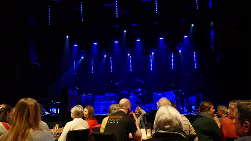 Tromsø – Longyearbyen Das einzige Konzert heute Abend, das „Vorspiel“. In der vordersten Reihe stehen Tische mit Stühlen, dahinter sind Stuhlreihen.