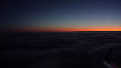 Tromsø – – – Longyearbyen Vorbereitung zu Landung, gleich geht es in die Wolkendecke rein. Blick nach Süden, letzte Sonnenstrahlen.
