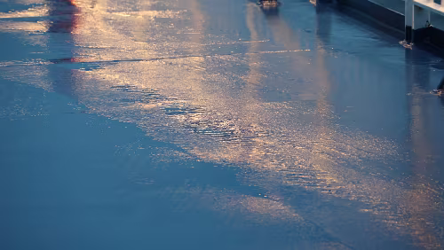 Føroyar Der Wind schafft skurrile Muster in die Pfützen an Deck.
