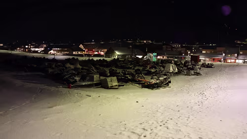 Longyearbyen Im Vordergrund ein Schneescooter-Parkplatz. Rechts der Kindergarten „Kullungen barnehage“.