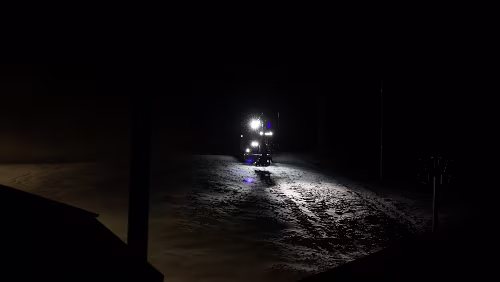 Longyearbyen Auf der Skipiste fährt ein Bagger ganz langsam herab, es sieht aus als ob er jeden Moment nach vorne kippen würde.